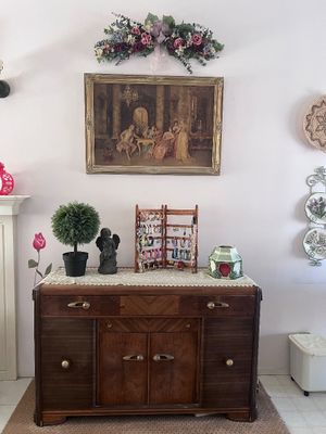 Sale Photo Thumbnail #14: Vintage Art Deco wood buffet cabinet with mixed veneer detailing, displayed with decorative home accents and framed wall art.