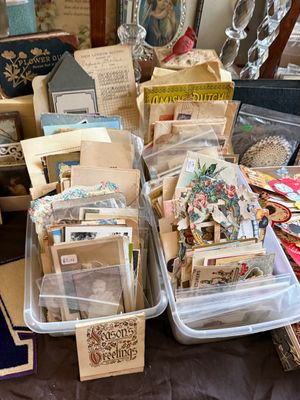 Sale Photo Thumbnail #74: Collection of vintage postcards, die-cut ephemera, and antique photographs displayed in clear plastic bins.
