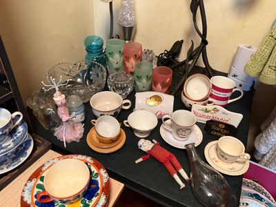Sale Photo Thumbnail #109: Collection of vintage tabletop decor, including frosted floral tumblers, cut glass bowls, assorted teacups, porcelain saucers, a small bisque doll, and Sango China display pieces.