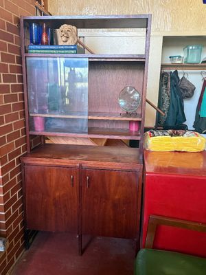Sale Photo Thumbnail #153: Mid-century modern dark wood hutch with a lower two-door cabinet, open shelving, and a glass-paneled display section.