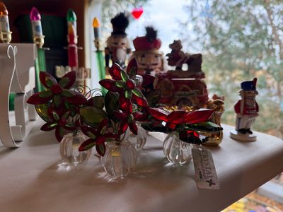 Sale Photo Thumbnail #119: Collection of holiday decorations, including Crystal Expressions by Ganz glass poinsettia figurines, miniature nutcrackers, and electric bubble lights.