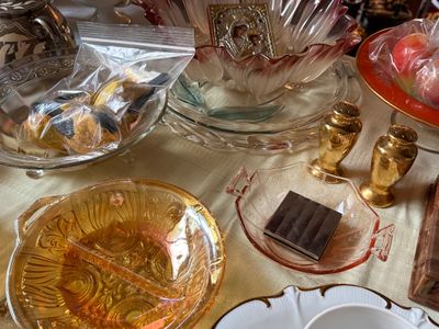 Sale Photo Thumbnail #50: Collection of vintage glass tableware including marigold iridescent depression glass, pink etched glass, gold-toned salt and pepper shakers, and decorative glassware.