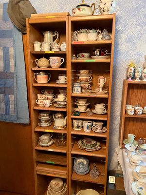 Sale Photo Thumbnail #97: Pair of tall, narrow oak display cabinets filled with vintage and antique porcelain teacups, saucers, and teapots.