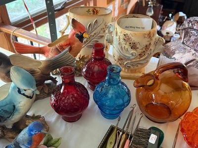 Sale Photo Thumbnail #59: Collection of vintage glassware and ceramics, including colorful pressed glass bottles, bird figurine planters, and a Red Wing pottery vase.
