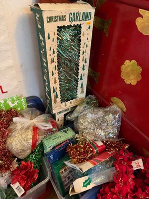 Sale Photo Thumbnail #129: Vintage Christmas garland and holiday decorations, featuring green tinsel in original retail box alongside assorted red and gold tinsel garlands.