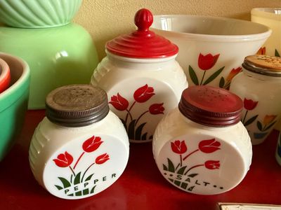 Sale Photo Thumbnail #4: Vintage Fire-King milk glass salt and pepper shakers with red tulip pattern, accompanied by matching grease jar and mixing bowls.