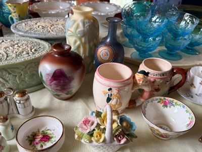 Sale Photo Thumbnail #47: Collection of vintage porcelain and glassware, including art glass vases, floral teacups, decorative ceramic mugs, and blue depression glass sherbet dishes.