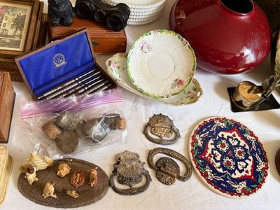 Sale Photo Thumbnail #20: Collection of vintage table decor and small collectibles, including floral china saucers, antique drawer pulls, a boxed nut pick set, a mini nativity scene, and a ceramic trivet.