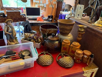 Sale Photo Thumbnail #124: Collection of vintage tabletop items including ceramic pots, a teapot with wire handle, wooden shakers, metal basket wall pockets, and a porcelain figurine.
