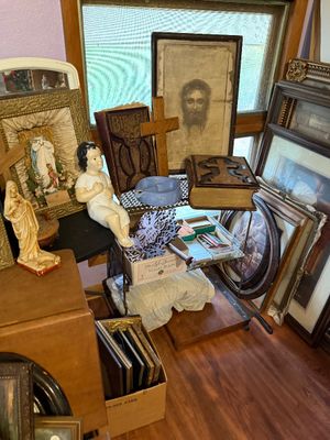 Sale Photo Thumbnail #95: Collection of vintage religious items including framed Jesus artwork, figurines, heavy leather-bound Bibles, wooden crosses, and framed prints.