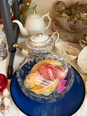 Sale Photo Thumbnail #24: Vintage cut glass fruit bowl filled with decorative stone fruit, displayed alongside vintage porcelain teapots and decorative ceramic figures.