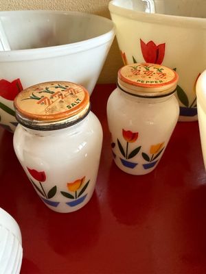 Sale Photo Thumbnail #5: Vintage McKee or Jeanette milk glass salt and pepper shakers featuring a colorful tulip pattern, paired with matching mixing bowls in the background.