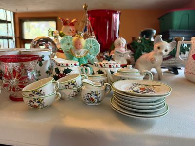 Sale Photo Thumbnail #120: Collection of vintage Christmas decor, including a miniature nursery rhyme porcelain tea set, crackle glass hurricane vase, holly leaf pottery, figurines, and holiday ornaments.
