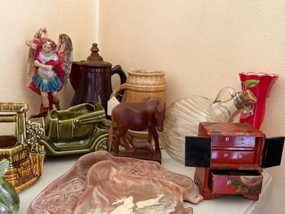Sale Photo Thumbnail #32: Collection of vintage decor items, including ceramic planters, an archangel figure, a miniature red wooden jewelry cabinet, and a carved wooden donkey figurine.