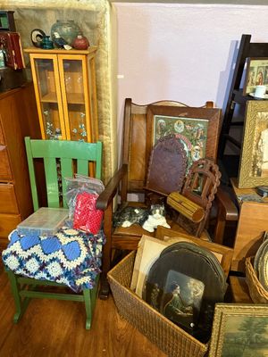 Sale Photo Thumbnail #90: Collection of vintage home decor and furniture, including a green painted rocking chair, leather-upholstered armchair, ceramic cat figurine, framed art, and woven storage baskets filled with artwork.