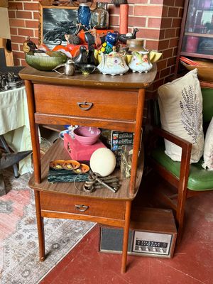 Sale Photo Thumbnail #42: Mid-century wooden two-tier telephone table holding various vintage collectibles, glassware, and decorative trinkets.