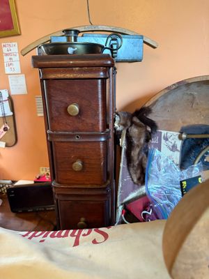 Sale Photo Thumbnail #142: Vintage tall narrow wooden spooled cabinet with brass knobs, topped with a brass chamberstick candle holder.