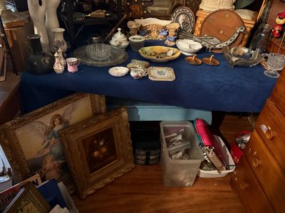 Sale Photo Thumbnail #85: Tabletop display featuring vintage glassware, porcelain trinket dishes, small brass items, and framed artwork resting below.