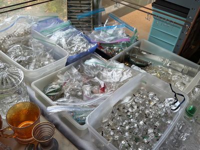 Sale Photo Thumbnail #38: Plastic bins containing a large collection of clear glass crystal chandelier prisms and replacement glass pieces, organized in plastic bags.