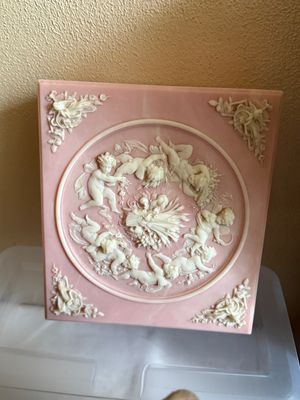 Sale Photo Thumbnail #14: Vintage pink marble-like plaque featuring a neoclassical bas-relief medallion of cherubs in a ring, accented with ornate corner motifs.