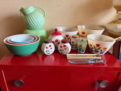 Sale Photo Thumbnail #3: Collection of vintage Fire-King and jadeite glassware, including tulip-patterned salt and pepper shakers, mixing bowls, and a jadeite ball pitcher.