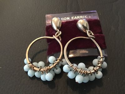 Sale Photo Thumbnail #27: Pair of vintage gold-tone clip-on drop earrings featuring circular hoops wrapped with wire and light blue glass or stone beads along the bottom. Mountings feature clip-on backs. Attached to original retail card labeled 'FASHION EARRINGS'. Pre-owned condit