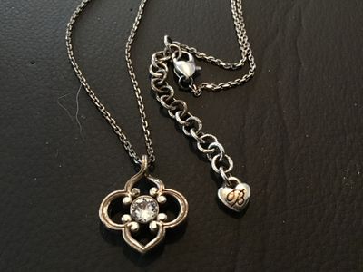 Sale Photo Thumbnail #104: Brighton silver-tone chain necklace featuring a clover/quatrefoil motif pendant set with a central clear crystal stone. Features an adjustable extender chain with the signature Brighton heart tag logo and lobster claw clasp. Pre-owned condition with minor