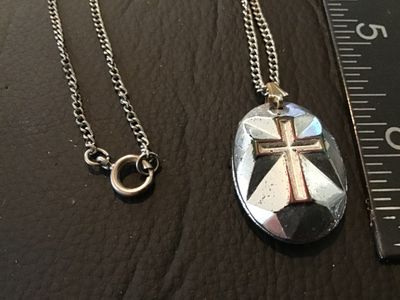 Sale Photo Thumbnail #35: Vintage silver-tone curb chain necklace featuring an oval pendant with an iridescent, stained-glass style multi-color cross design on one side and a faceted metallic cross motif on the reverse. Pendant measures approximately 1.25 inches long. Features a s