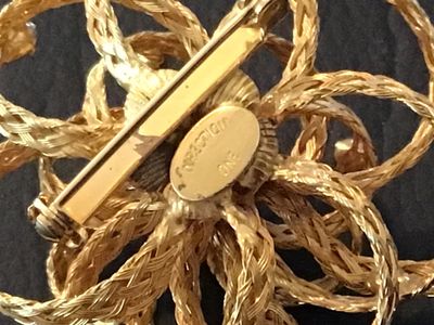 Sale Photo Thumbnail #22: Vintage gold-tone floral brooch featuring braided wire loops accents and set with clear rhinestones. Marked 'DIRECTION ONE' on an oval plaque on the back. Features a standard pin stem and roll-over safety clasp. In good vintage condition with light finish
