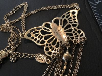 Sale Photo Thumbnail #39: Statement necklace featuring a large openwork butterfly focal piece adorned with red rhinestones and hanging chain fringe with rhinestone drops. Marked 'PILGRIM' on the back of the butterfly and 'DANISH DESIGN' on the metal tag near the clasp. Features a 