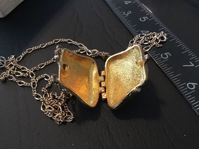 Sale Photo Thumbnail #58: gold-tone chain necklace featuring an ornate purse-shaped locket pendant with black enamel work and clear rhinestone accents. The locket opens on a bottom hinge with a textured gold-tone interior. Pendant measures approximately 1.5 inches wide by 1.25 inc