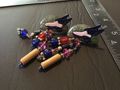 Sale Photo Thumbnail #83: Pair of bold vintage 1980s statement clip-on earrings featuring gold-glitter half-moon tops accented with winged roller skate motifs, dangling colorful multi-bead strands including blue, red, pink, and tan tube beads. Clip-on backs are intact. Measures ap