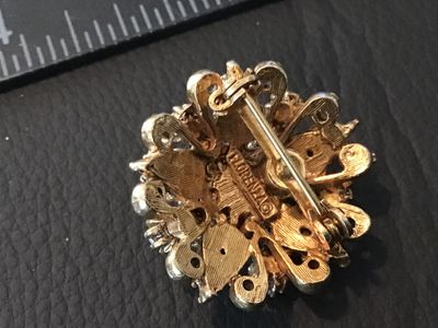 Sale Photo Thumbnail #5: A vintage ornate gold-tone brooch/pin by Florenza featuring a central faux turquoise cabochon surrounded by faux pearls and teardrop light blue rhinestones. Filigree/scrollwork detailing on a textured gold-tone setting. Signed FLORENZA© on the back. Meas