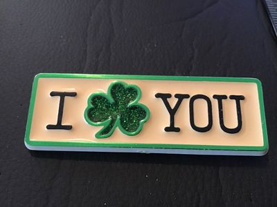 Sale Photo Thumbnail #19: Vintage plastic pin featuring 'I [Shamrock] YOU' with green glitter detailing inside the shamrock. The back is stamped '(C) 1985 HALLMARK CARDS, INC.' Standard pin back closure. Shows light wear consistent with age, overall in good condition.