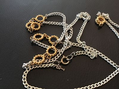 Sale Photo Thumbnail #81: Vintage Crown Trifari long station chain necklace featuring white enameling over curb chain links accented with textured gold-tone openwork circles. Features a spring ring clasp and the signature Anne Klein lion head logo hangtag. Measures approximately 3