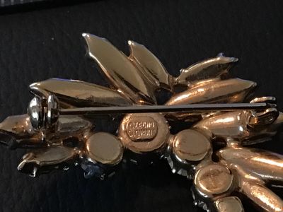Sale Photo Thumbnail #2: A vintage costume jewelry brooch featuring blue, green, and iridescent aurora borealis rhinestones in a stylized winged or floral spray setting. The back is stamped 'CZECHO SLOVAKIA'. Measures approximately 2 inches wide. Pin clasp on the reverse is intac