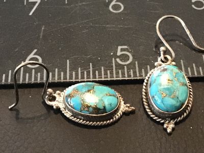 Sale Photo Thumbnail #103: Pair of sterling silver dangle/drop earrings featuring oval composite blue turquoise stones with brass/copper matrix. Detailed with rope trim and bead accents. Stamped '925' and 'INDIA' on the back. Measures approximately 1.25 inches long including fishho