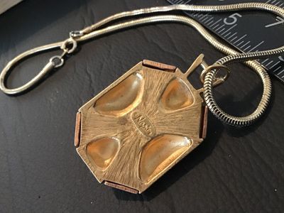 Sale Photo Thumbnail #68: Vintage Napier costume jewelry necklace featuring an emerald-cut amber/citrine color glass or rhinestone centerpiece set in a silver-tone bezel. The geometric pendant features alternating gold-tone and rose gold-tone panels with a textured back stamped wi