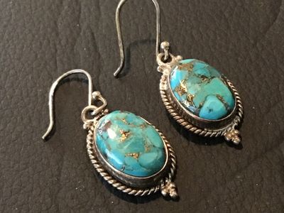 Sale Photo Thumbnail #101: Pair of sterling silver dangle/drop earrings featuring oval composite blue turquoise stones with brass/copper matrix. Detailed with rope trim and bead accents. Stamped '925' and 'INDIA' on the back. Measures approximately 1.25 inches long including fishho