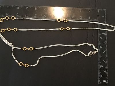 Sale Photo Thumbnail #82: Vintage Crown Trifari long station chain necklace featuring white enameling over curb chain links accented with textured gold-tone openwork circles. Features a spring ring clasp and the signature Anne Klein lion head logo hangtag. Measures approximately 3
