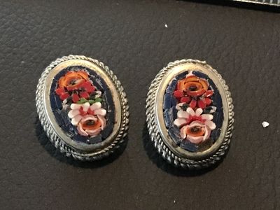Sale Photo Thumbnail #114: Pair of vintage oval micro mosaic clip-on earrings featuring a detailed colorful floral design set in silver-tone metal frames with rope border details. Stamped 'ITALY' on the back. Clip-on backs function properly. Shows minor vintage wear and patina cons