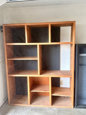Sale Photo Thumbnail #39: Large wooden cubby bookcase with asymmetrical shelving compartments and a dark backing.