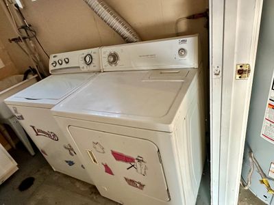 Sale Photo Thumbnail #34: A matching white Estate heavy-duty washing machine and electric dryer pair, featuring laundry-themed decals on the front panels.
