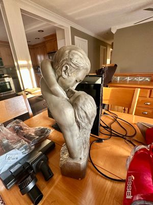 Sale Photo Thumbnail #23: Silver-toned sculpture of an embracing kissing couple on a table alongside various household electronics.