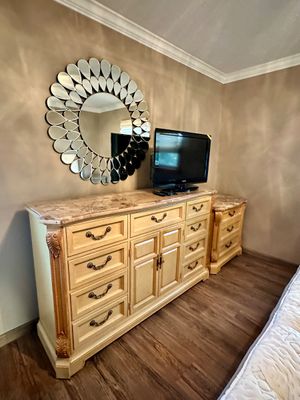 Sale Photo Thumbnail #14: Traditional light wood dresser set with marble-look tops and brass hardware, paired with a modern teardrop petal sunburst wall mirror.