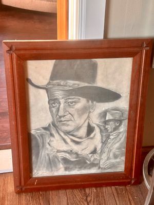 Sale Photo Thumbnail #31: Framed original charcoal portrait drawing of John Wayne in a cowboy hat, signed and dated 1979, set within a rustic wooden frame.