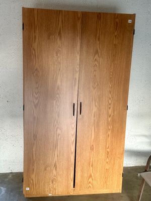 Sale Photo Thumbnail #38: Tall light oak finish two-door storage wardrobe cabinet featuring dark slim pull handles.