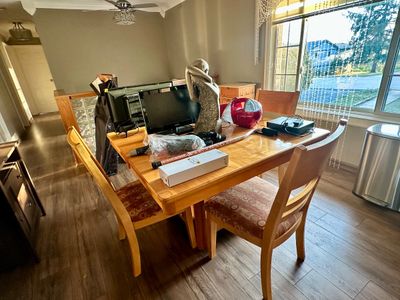Sale Photo Thumbnail #28: Light oak dining table set with upholstered chairs, displayed with various electronics and household items.