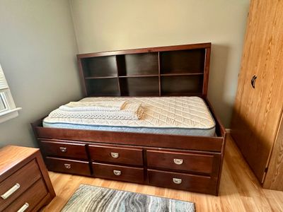 Sale Photo Thumbnail #17: Dark wood captains bed frame featuring built-in storage drawers below and an integrated bookcase headboard.