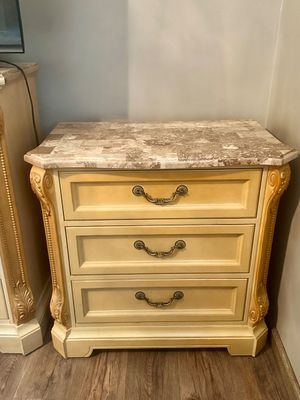 Sale Photo Thumbnail #12: Traditional French Provincial style three-drawer nightstand with a beige painted finish, carved pilasters, brass bail pulls, and a faux-marble top.